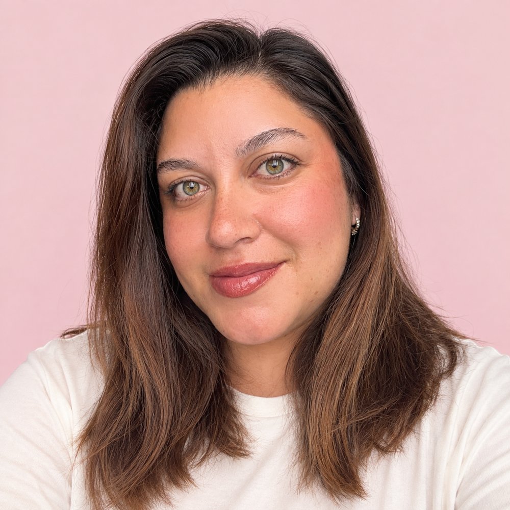Gaby sonriendo frente a un fondo rosa
